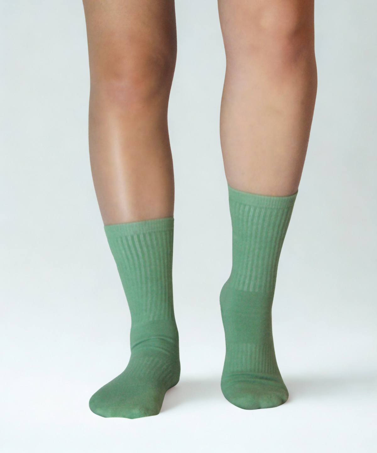 Green socks worn by a person on a white background