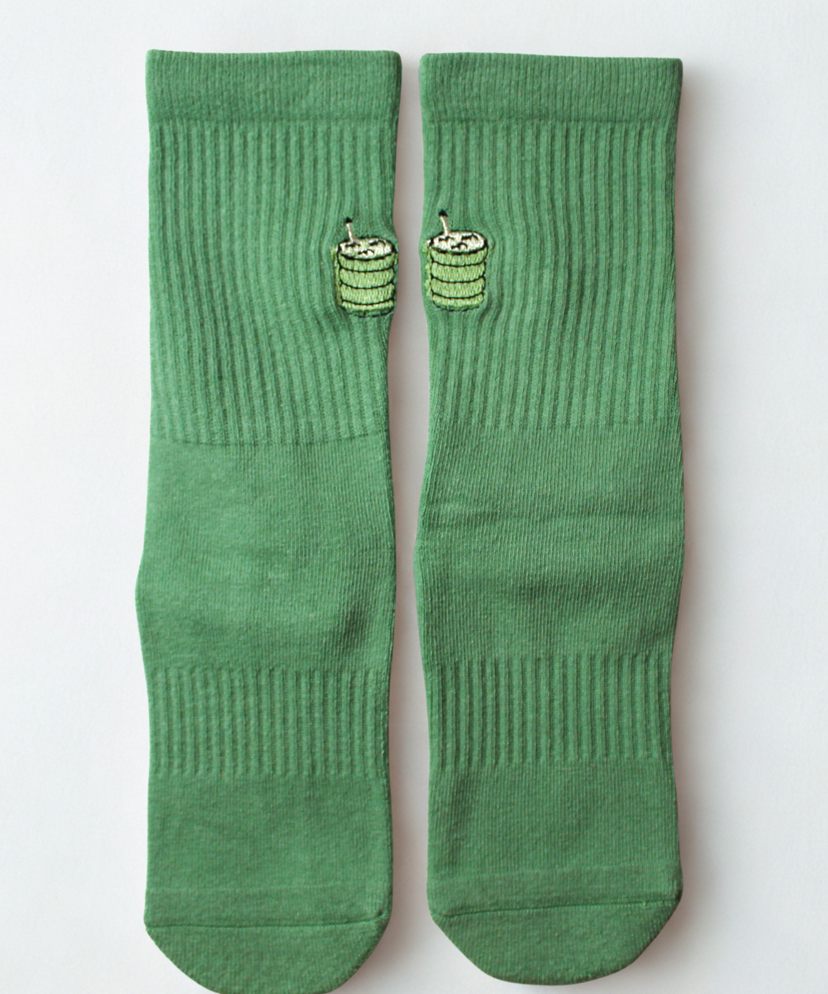 Pair of green socks with a small green design on a light gray background