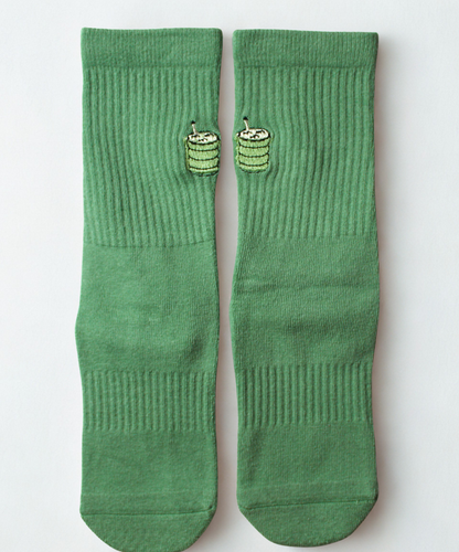 Pair of green socks with a small green design on a light gray background