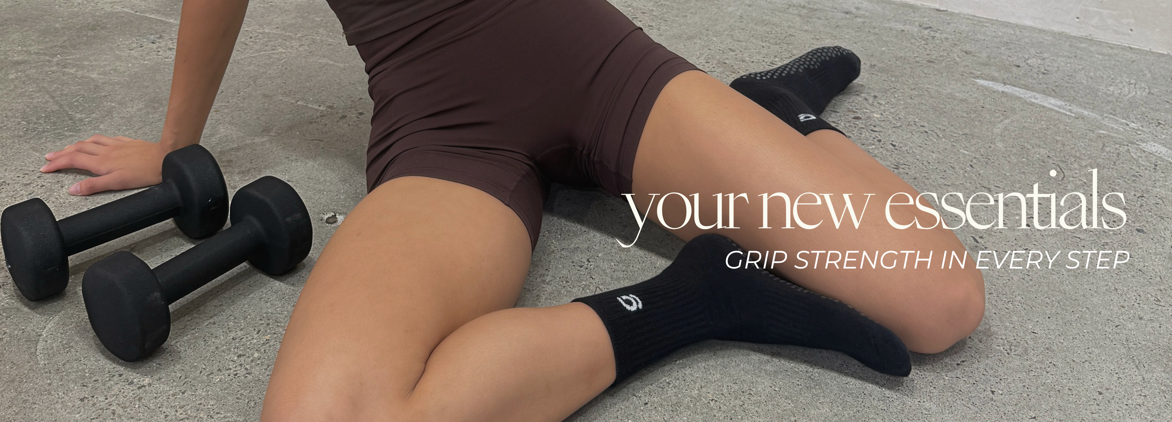 Model wearing black crew grip socks with dumbbells and text 'your new essentials'