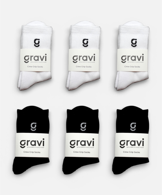 Set of white and black socks with 'gravi' branding on a light gray background