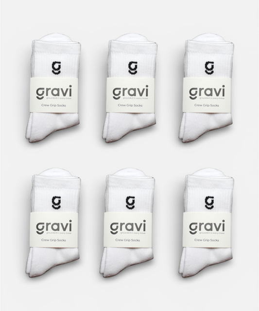 Set of six white socks with 'gravi' branding on a light gray background