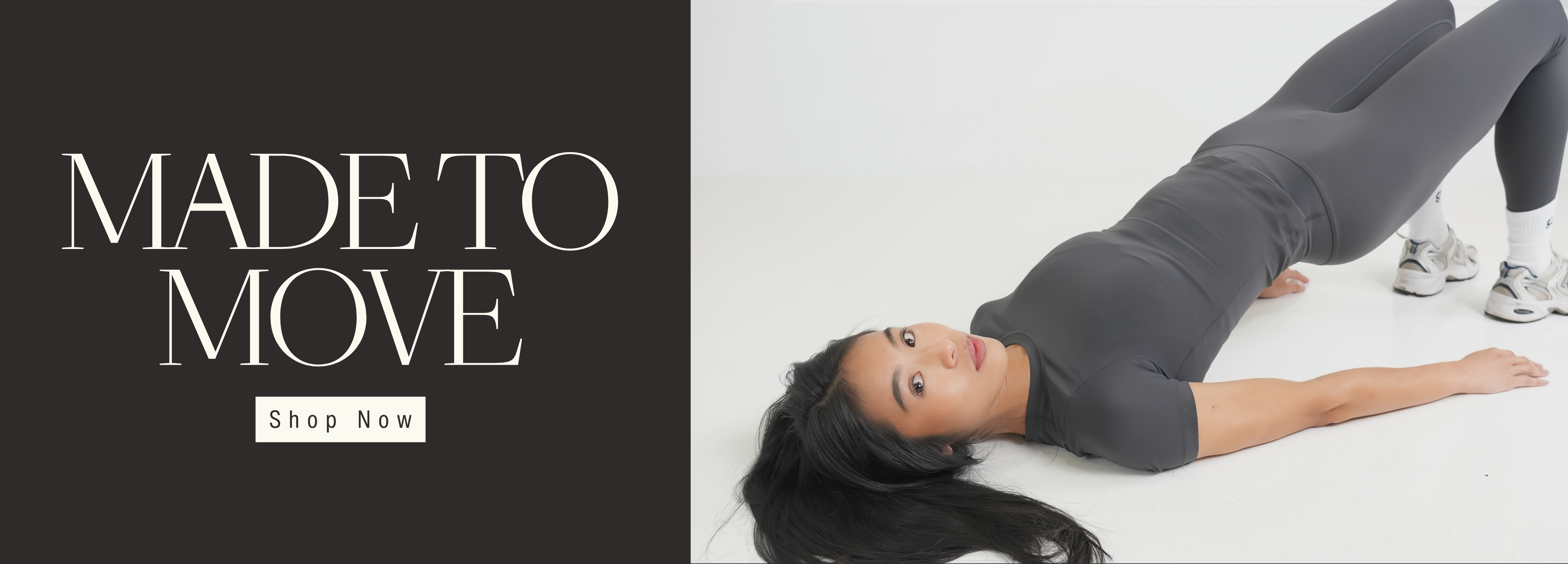 Woman lying on a white floor wearing gray athletic pants with grip socks and 'Made to Move' text and 'Shop Now' button