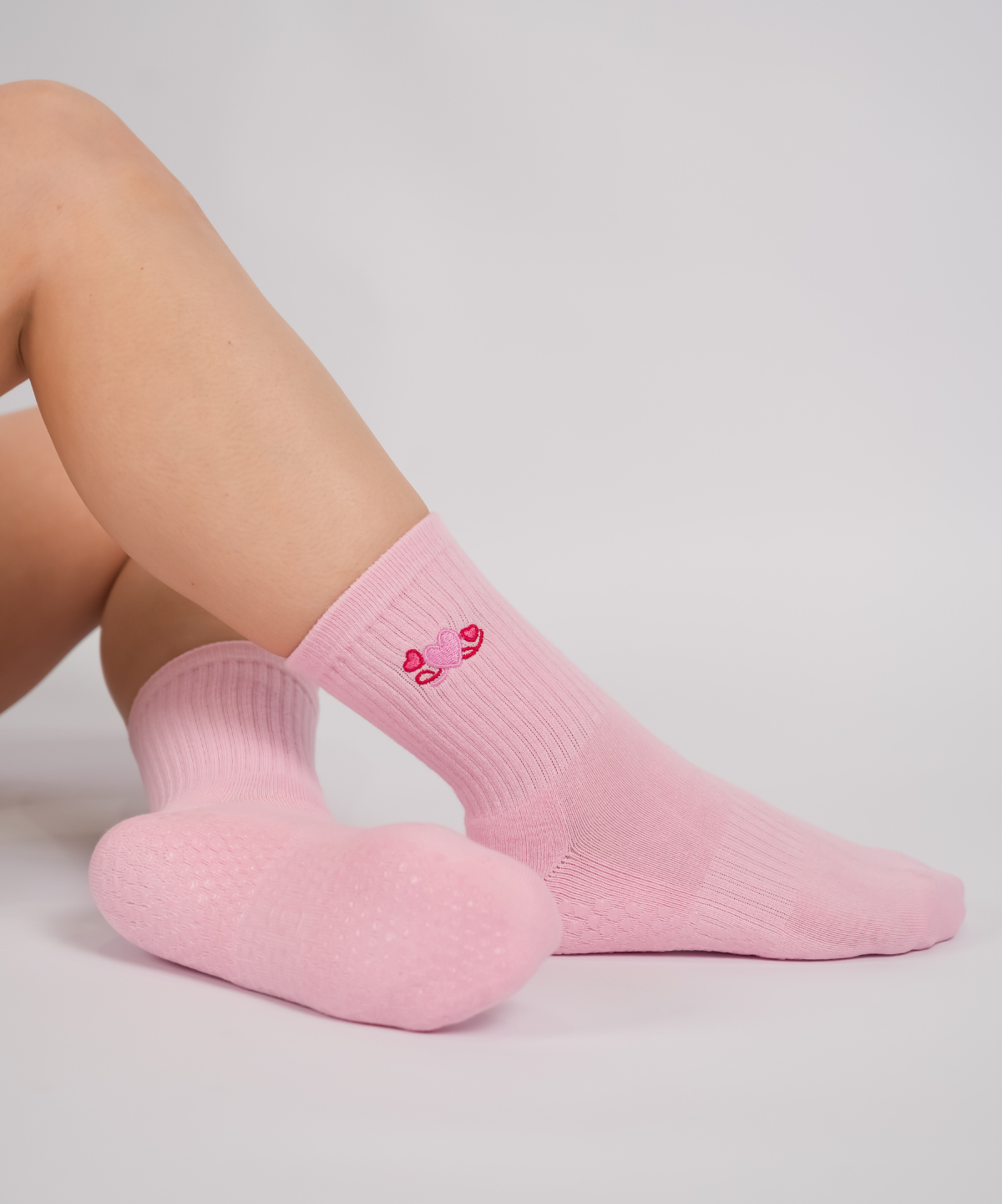 Pink socks with a heart design on a light gray background