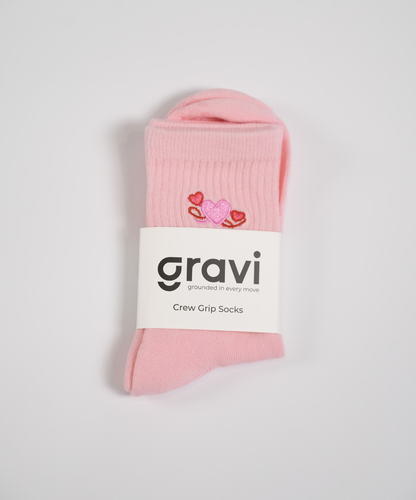 Pink socks with a 'gravi' label on a light gray background