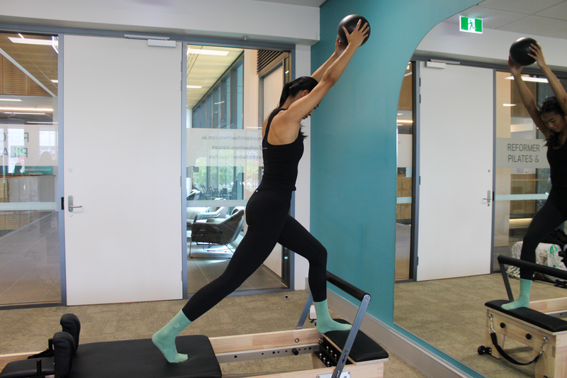 Person exercising with a kettlebell on a reformer