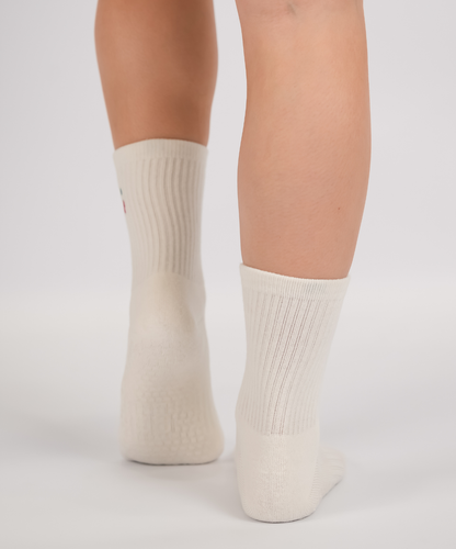 White socks with cherry design worn by a person on a light gray background