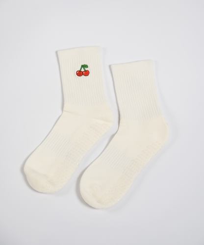 Pair of cream socks with a cherry design on a light gray background